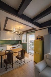 a kitchen with a table and a yellow refrigerator at Gangneung Wheel Hotel in Gangneung