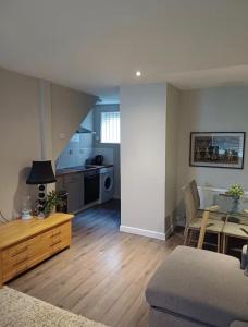 a living room with a table and a kitchen at The Mews Holywell in Holywell