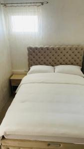 a large white bed in a bedroom with a window at Panorama - 2 Lazarevac in Lazarevac