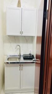 a kitchen with white cabinets and a sink at Panorama - 2 Lazarevac in Lazarevac