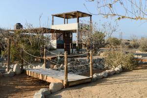 a building in the middle of a desert with rocks at Ohana cerritos in El Pescadero