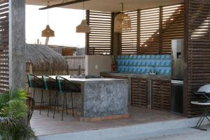 a kitchen with a counter with chairs and a stove at Ohana cerritos in El Pescadero
