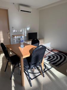 a table with four chairs in a room with a bed at Trendy Edge Apartments in Nadi
