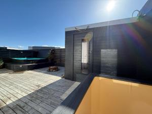 a black house with a pool on a roof at Studio with Private Spa Garden in Njarðvík