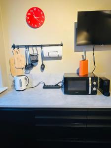 a counter with a microwave and a clock on a wall at Studio with Private Spa Garden in Njarðvík +8 photos