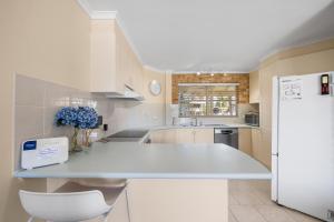 a kitchen with a white counter and a refrigerator at Ocean Shores Apartment 2 in South West Rocks +24 photos