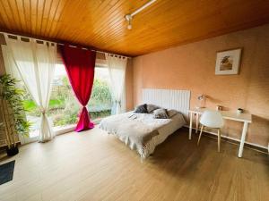 ein Schlafzimmer mit Bett, Schreibtisch und Fenster in der Unterkunft Chambres Spacieuses et Lumineuses - Angers - Votre havre de paix in Angers
