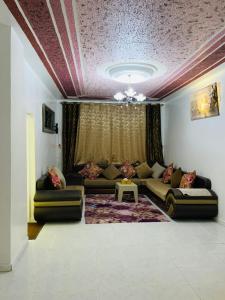a living room with couches and a purple ceiling at Maison yassine in Douz