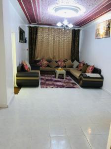 a living room with a couch and a table at Maison yassine in Douz