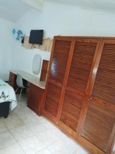 a room with a desk and a wooden closet at J&J Paradise Guesthouse in Pietermaritzburg