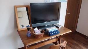 a television sitting on a wooden table with a basket at MtFuji Homestay Leoya in Fuji