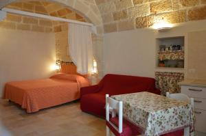 ポリニャーノ・ア・マーレにあるLa dimora di Poseidoneのベッドルーム1室(ベッド1台、赤い椅子、テーブル付)