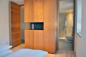a bedroom with a large wooden door leading to a bathroom at Apartments Frieda in Valdaora