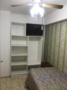a bedroom with a bed and a flat screen tv at Hotel Simon II in Antofagasta