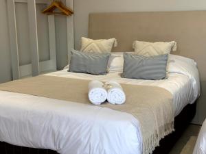a large bed with two white towels on it at Casa KOMU in Asunción