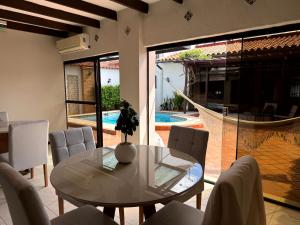 a dining room with a table and chairs and a pool at Casa KOMU in Asunción