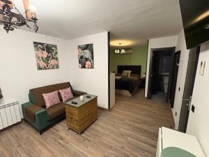 a living room with a couch and a bed at Sueña Toledo- Apartamentos turisticos con piscina in Toledo +35 photos