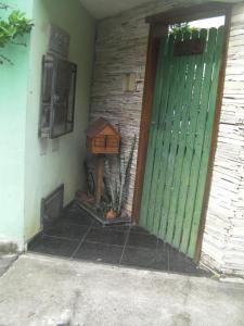 Pousada Dom Diego في جاكارابي: باب أخضر مع منزل الطيور على جانب المنزل