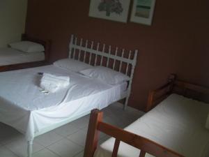 1 dormitorio con 2 camas con sábanas blancas en Pousada Dom Diego en Jacaraípe