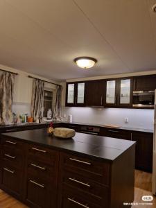 a kitchen with a black counter top and wooden cabinets at Trysil sentrum apartment in Trysil