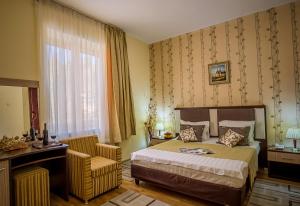 una camera con letto, scrivania e sedia di Hotel Rina Cerbul a Sinaia