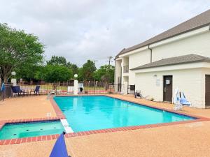 a swimming pool in front of a building at Days Inn by Wyndham Granbury in Granbury