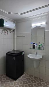 a bathroom with a sink and a mirror at Rose House - Quảng Bình in Bố Trạch
