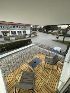 a deck with two chairs and a table on a building at R&B pension in Ichenhausen