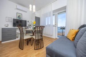 a living room with a table and chairs and a kitchen at Casa Vita in Dramalj