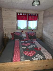 a bedroom with a bed with a blanket on it at Le chalet des Cambuses in Saint Die