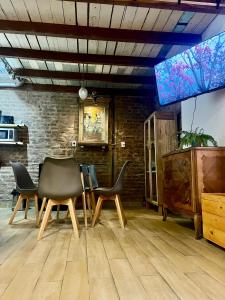 a room with chairs and a table and a wall at Loft con patio frente a Mercado San Telmo, 2 baños in Buenos Aires