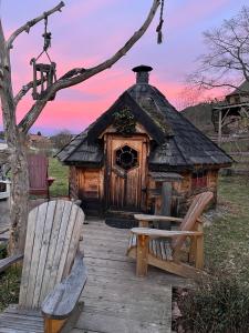 a log cabin with two chairs and a bench at Le chalet des Cambuses in Saint Die
