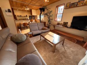 a living room with a couch and a coffee table at HAPPY MAGIC guesthouse in Tateyama