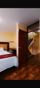 a bedroom with a bed with a staircase in the background at Kaypi Yireh in Cabanaconde