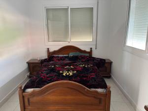 a bedroom with a wooden bed in a room with a window at Villa Meryem in Tangier