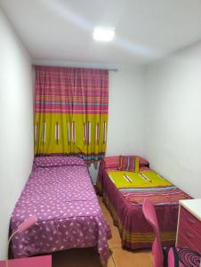 two beds in a small room with a window at Los Lentiscares Apartment in Torrox Costa