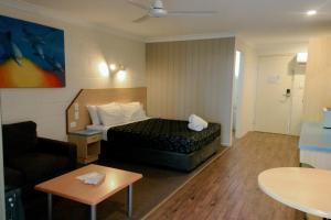 a hotel room with a bed and a couch at Pialba Motor Inn in Hervey Bay