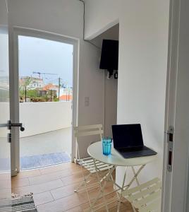 a laptop on a table in a room with a balcony at Yellow Guesthouse in Faro