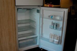 an empty refrigerator with its door open in a kitchen at Pialba Motor Inn in Hervey Bay