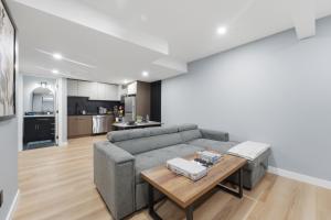 a living room with a couch and a table at Mountain Escape Deluxe King Suite-Free Parking in Cochrane