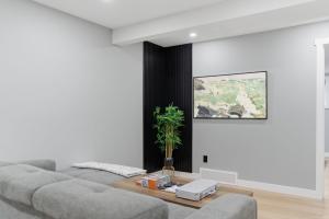 a living room with a couch and a table at Mountain Escape Deluxe King Suite-Free Parking in Cochrane