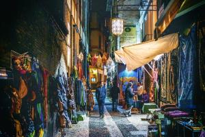 a group of people walking through an alley in a market at Antares in Granada