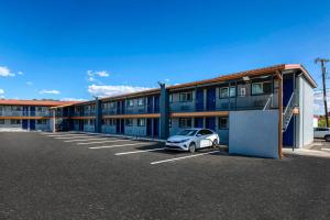 a car parked in a parking lot in front of a building at Copper Manor Motel in Silver City
