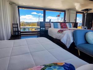 a room with two beds and a couch and a window at Uros Killa Lodge in Puno