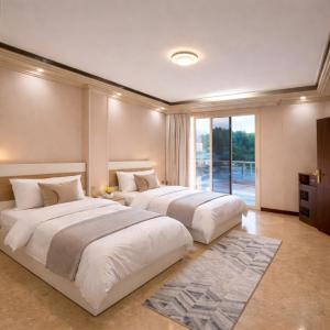 two beds in a large bedroom with a window at Villa Celia -New Cairo in Cairo +15 photos