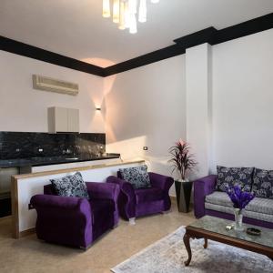 a living room with purple couches and a table at Villa Celia -New Cairo in Cairo