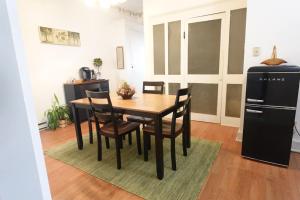 ein Esszimmer mit Tisch, Stühlen und Kühlschrank in der Unterkunft Strassner Suites - Opal in Hermann + 14 Fotos