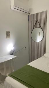 a bedroom with a bed and a desk and a lamp at Suíte Standard Privado in Vitória
