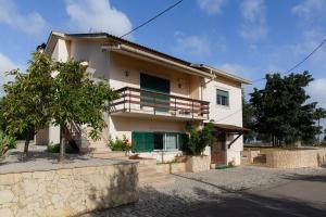 a house with a balcony and a tree at Casa da Lala - Alojamento a 4km de Fátima in Fontainhas