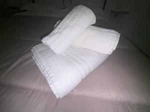 a stack of white towels on a bed at Il piccolo tempio di Ely in Termoli